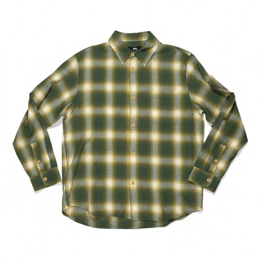 Green and yellow plaid shirt on a white surface