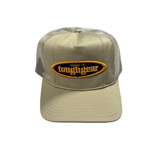 Beige cap with stussy oval 'toughgear' logo on a white surface