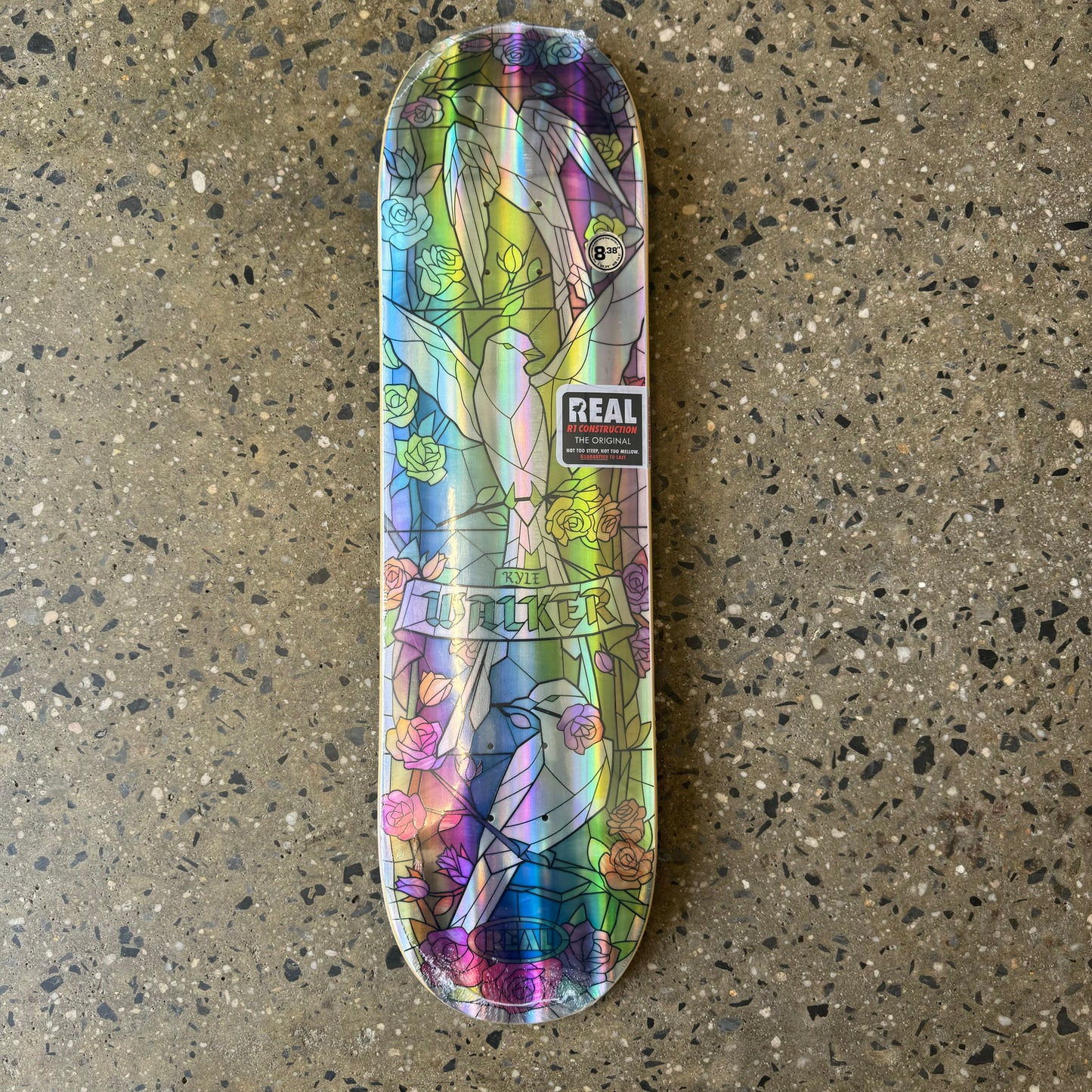 multi colored skateboard deck made to look like cathedral glass. holographic with doves in the center