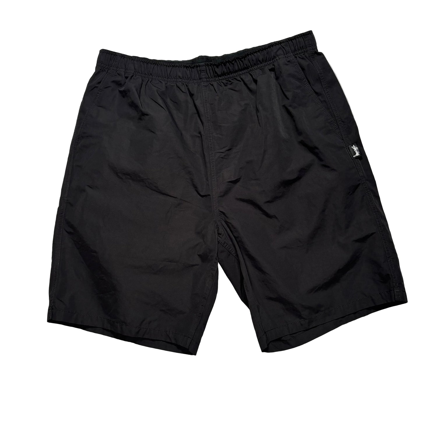 Black elastic waist stussy shorts on a white background