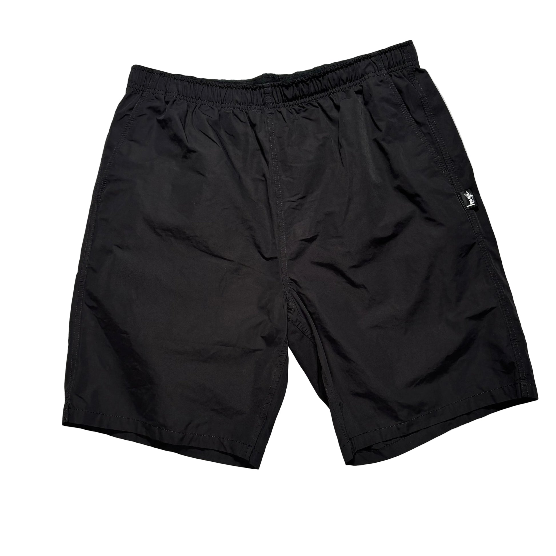 Black elastic waist stussy shorts on a white background
