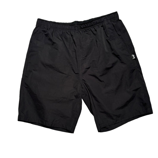 Black elastic waist stussy shorts on a white background