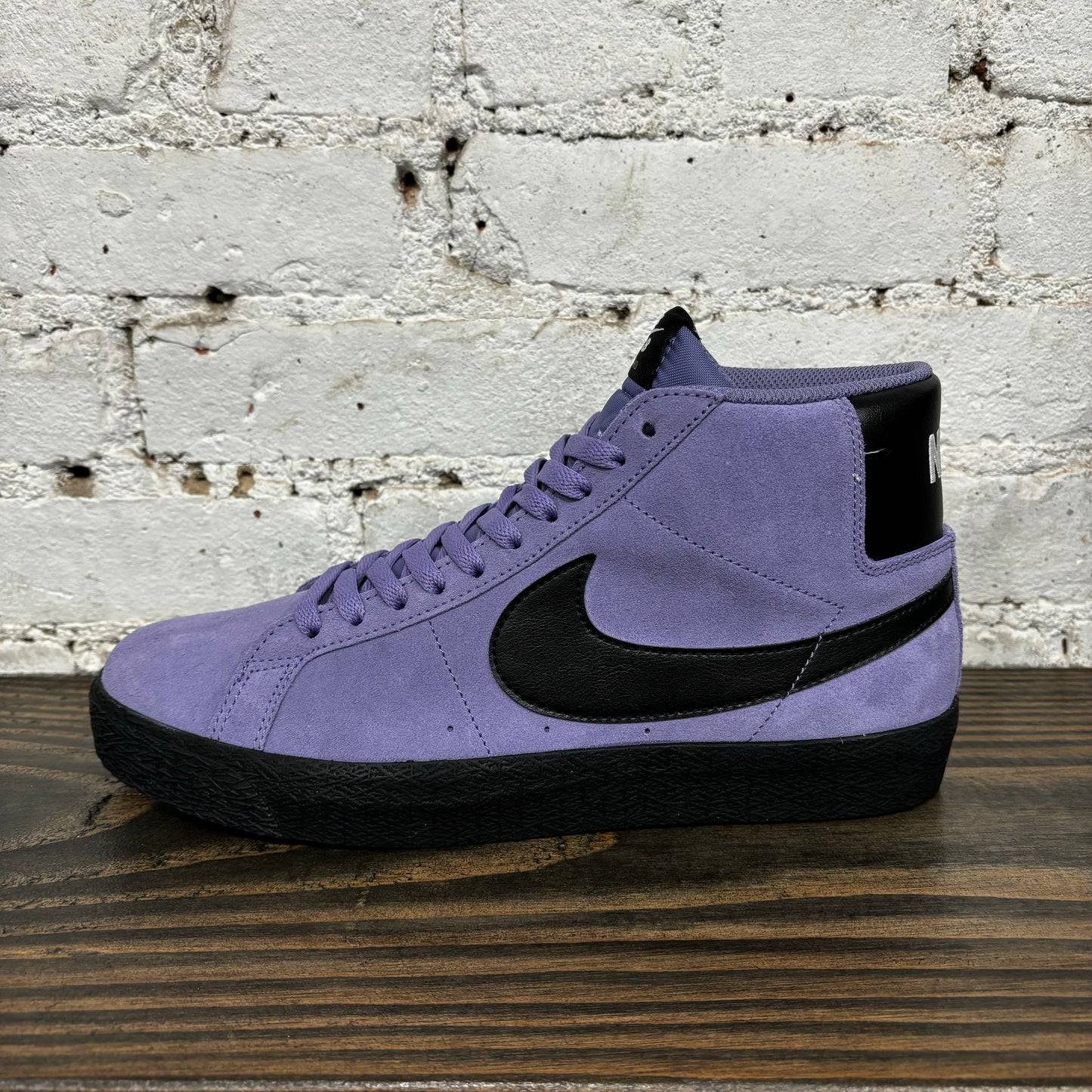 side view of light purple and black mid top suede sneaker