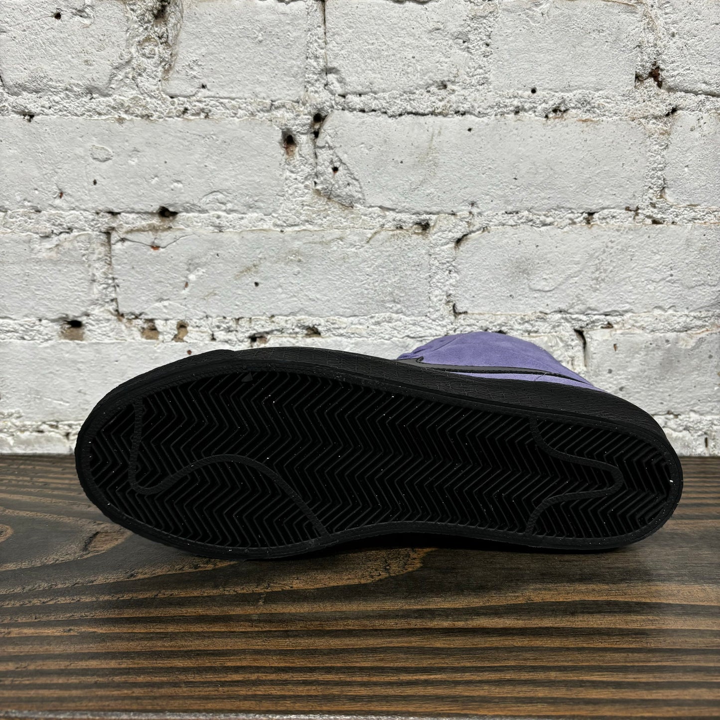 view of black outsole on light purple and black skateboard shoe