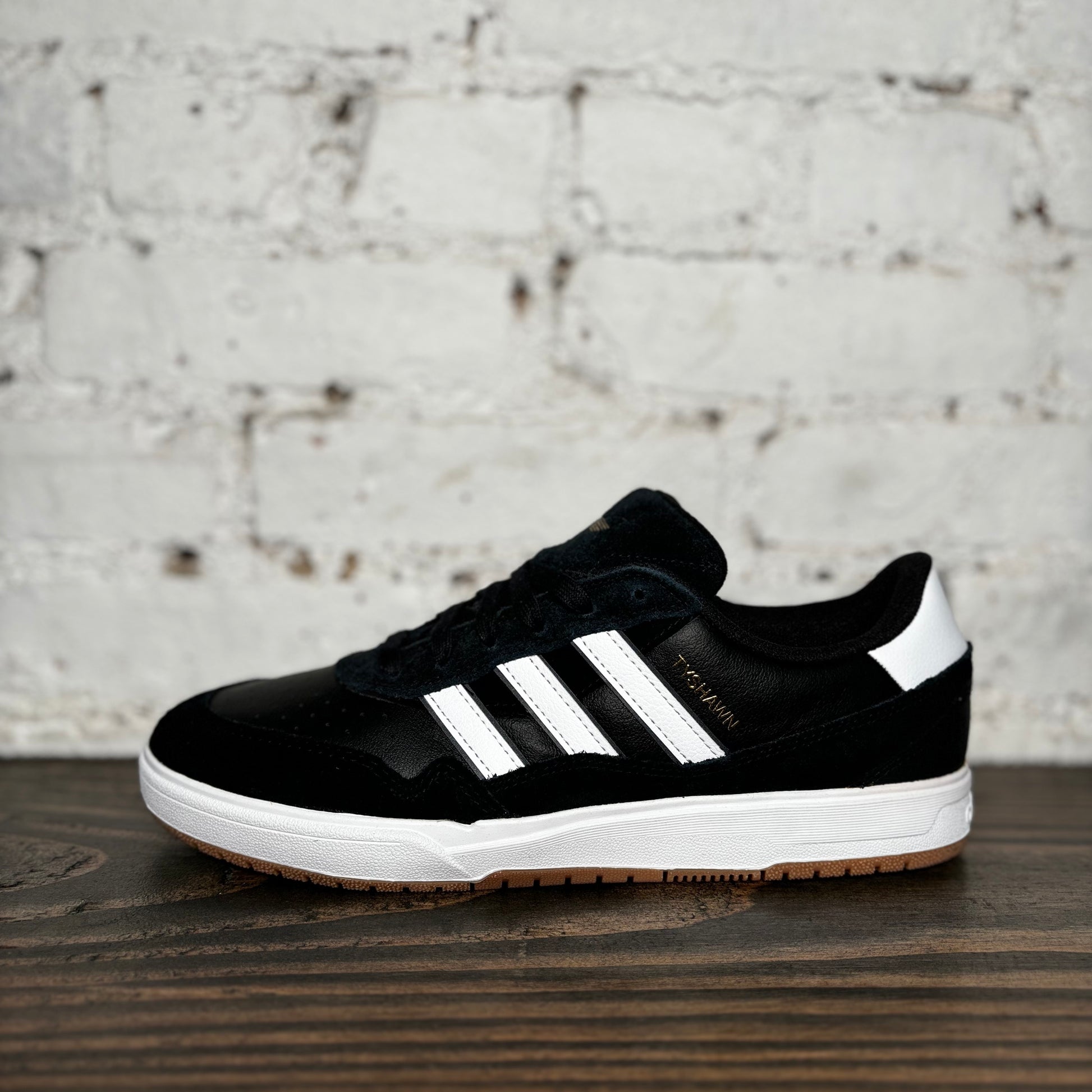 side view of black/white suede and leather low top adidas sneaker