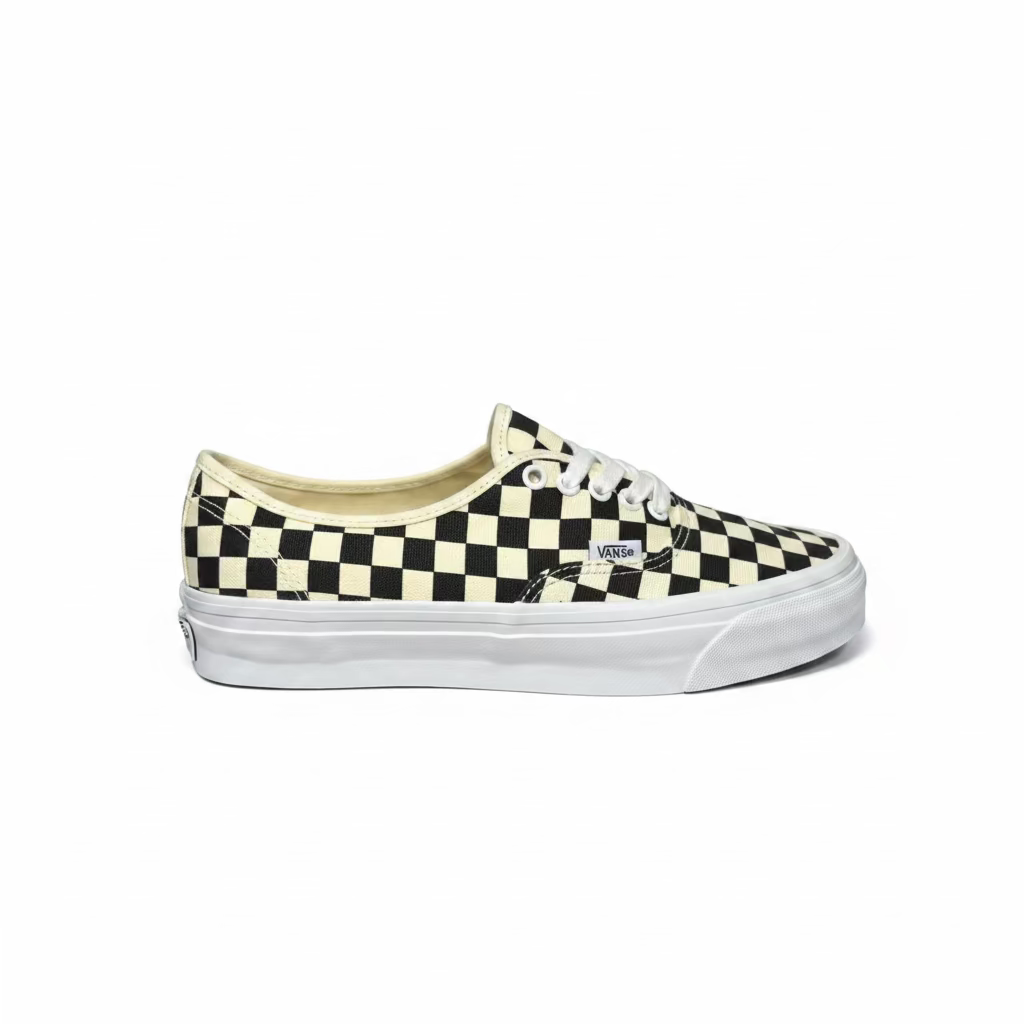 side view of black and white checkerboard deck shoe from vans, against white background