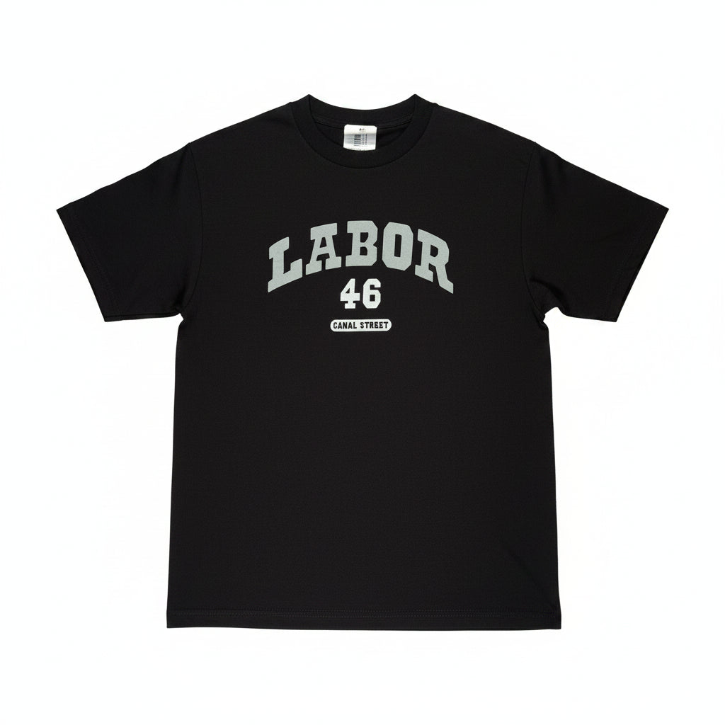 A black short-sleeve t-shirt laid flat on a white surface, featuring a light gray graphic print on the chest that reads 'LABOR 46' with 'CANAL STREET' underneath.