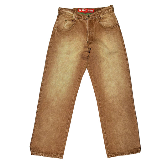 A pair of faded brown denim jeans laid flat on a white background. The jeans have a washed, vintage finish with a red and "C-STAR JEANS" label visible at the waistband.