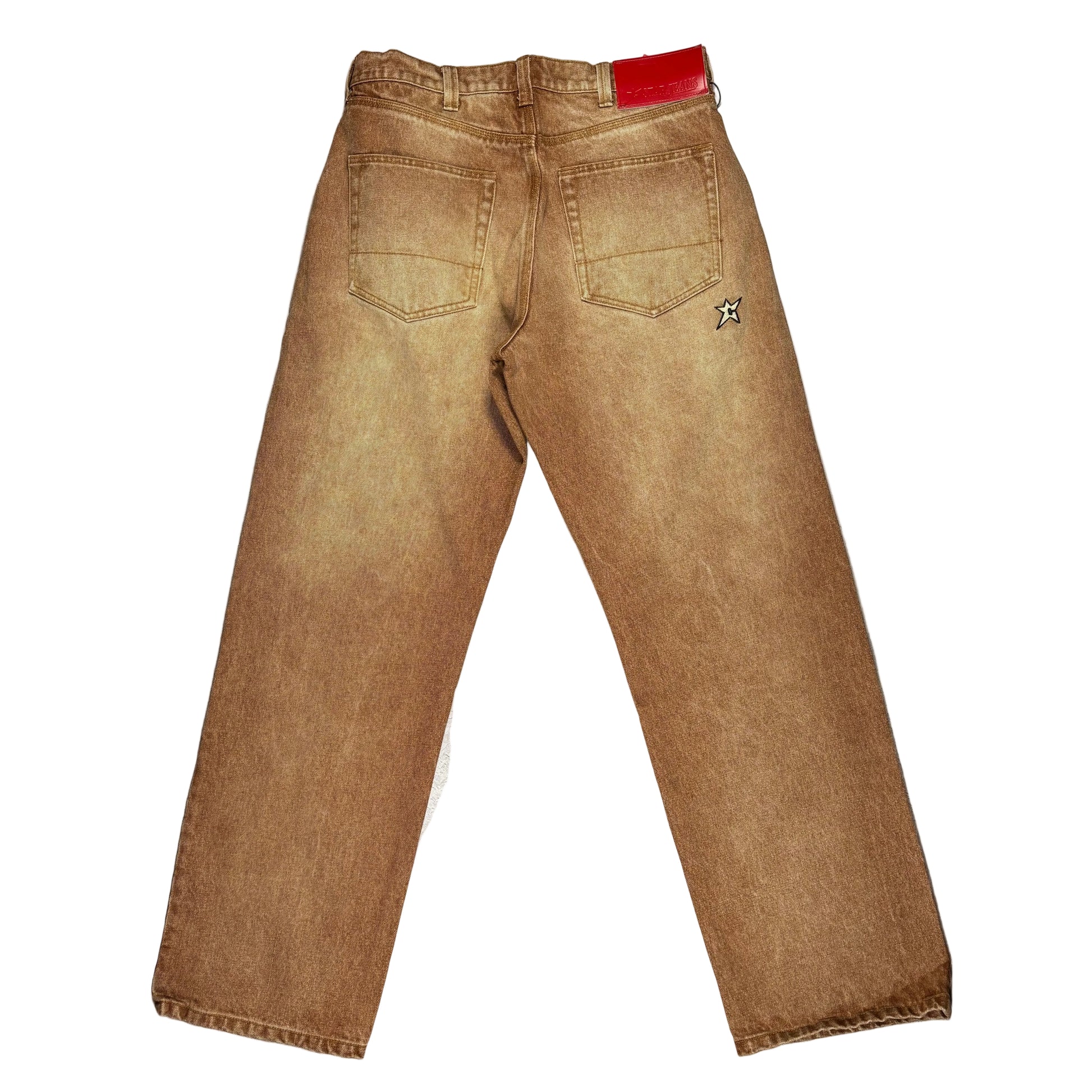 A pair of light brown washed denim jeans laid flat on a white background, viewed from the back. The jeans feature a small embroidered star logo on the upper right back pocket and a red leather patch on the back waistband.