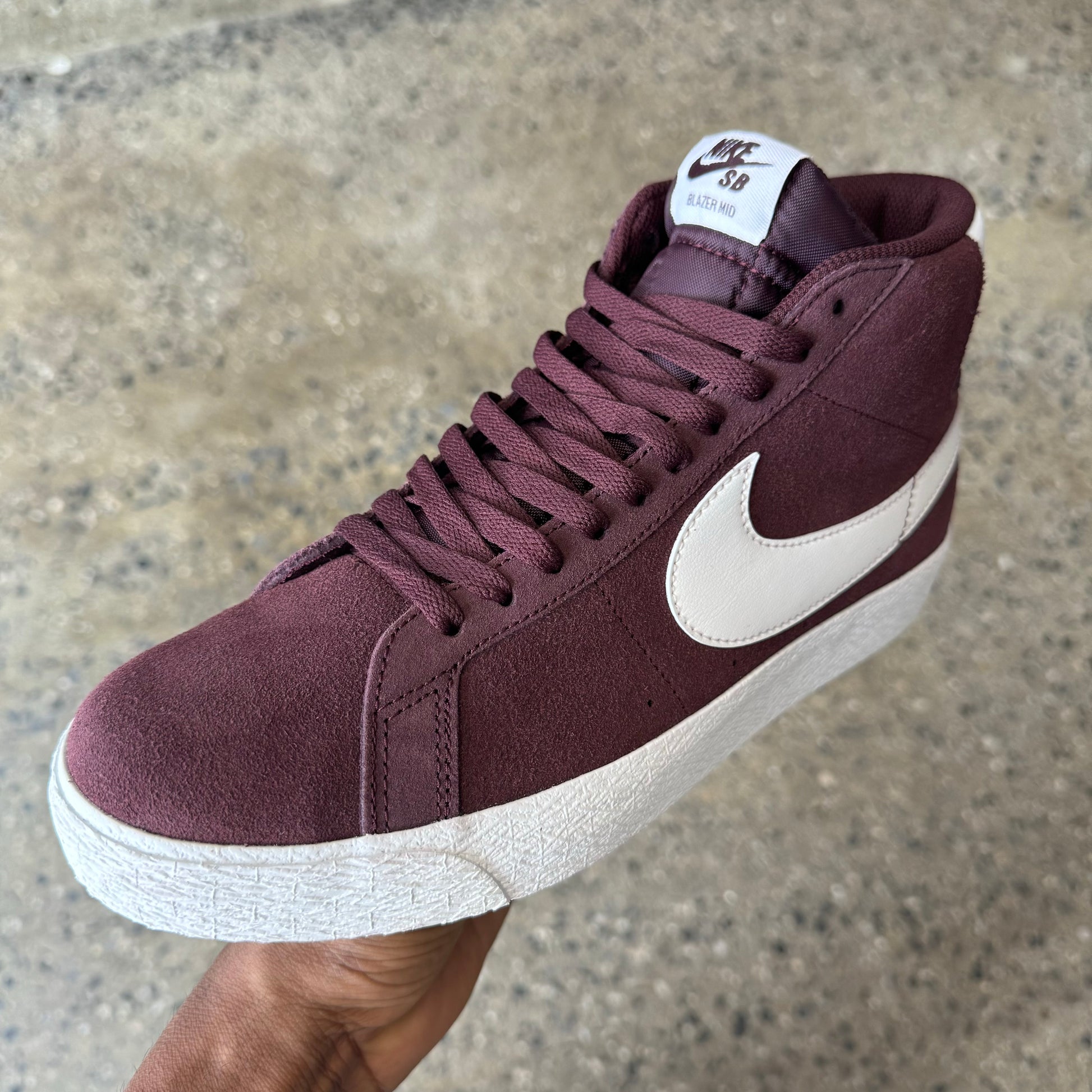 burgundy suede shoe with white nike logo and white rubber sole