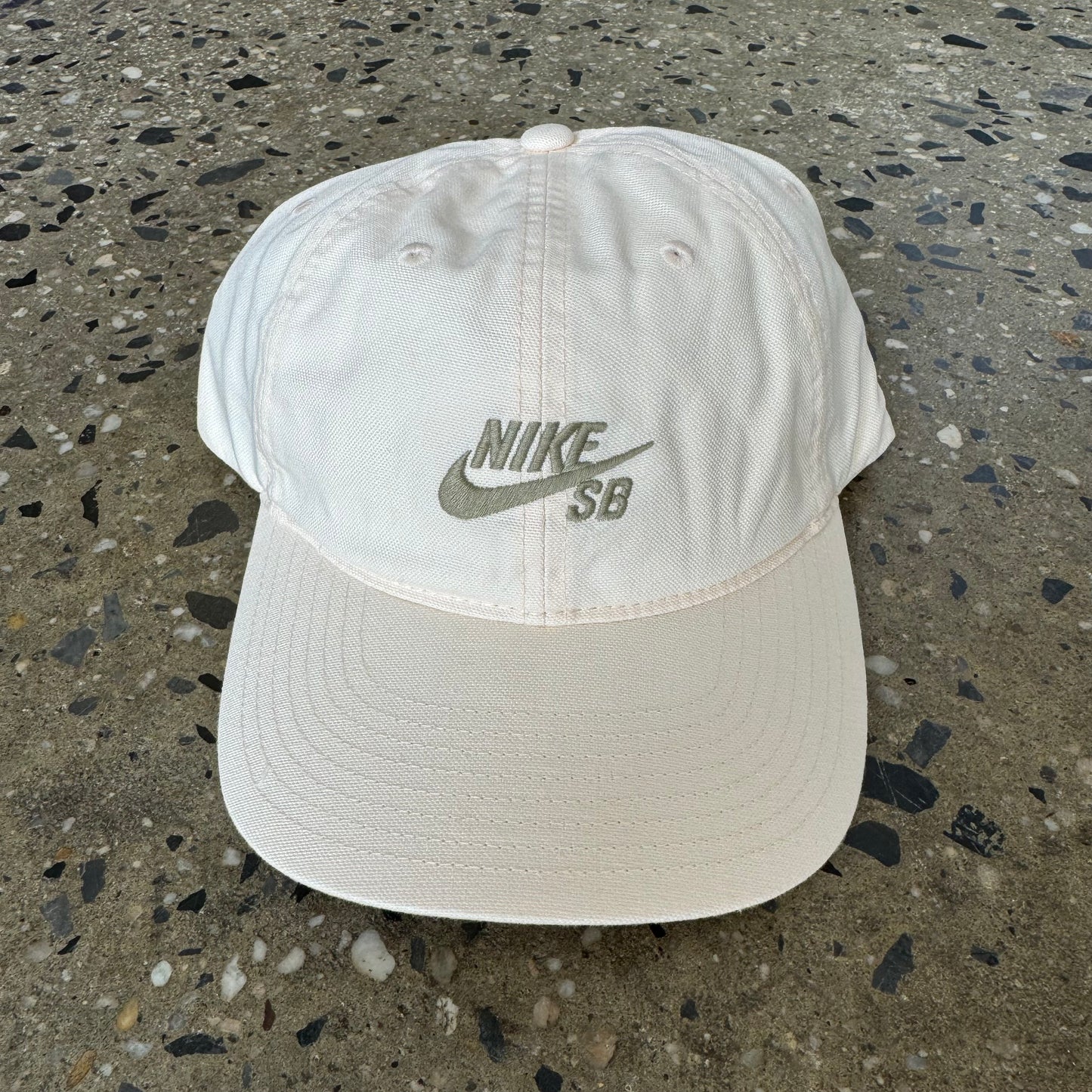 pastel/ light peach colored unstructured cap with white nike sb logo in center