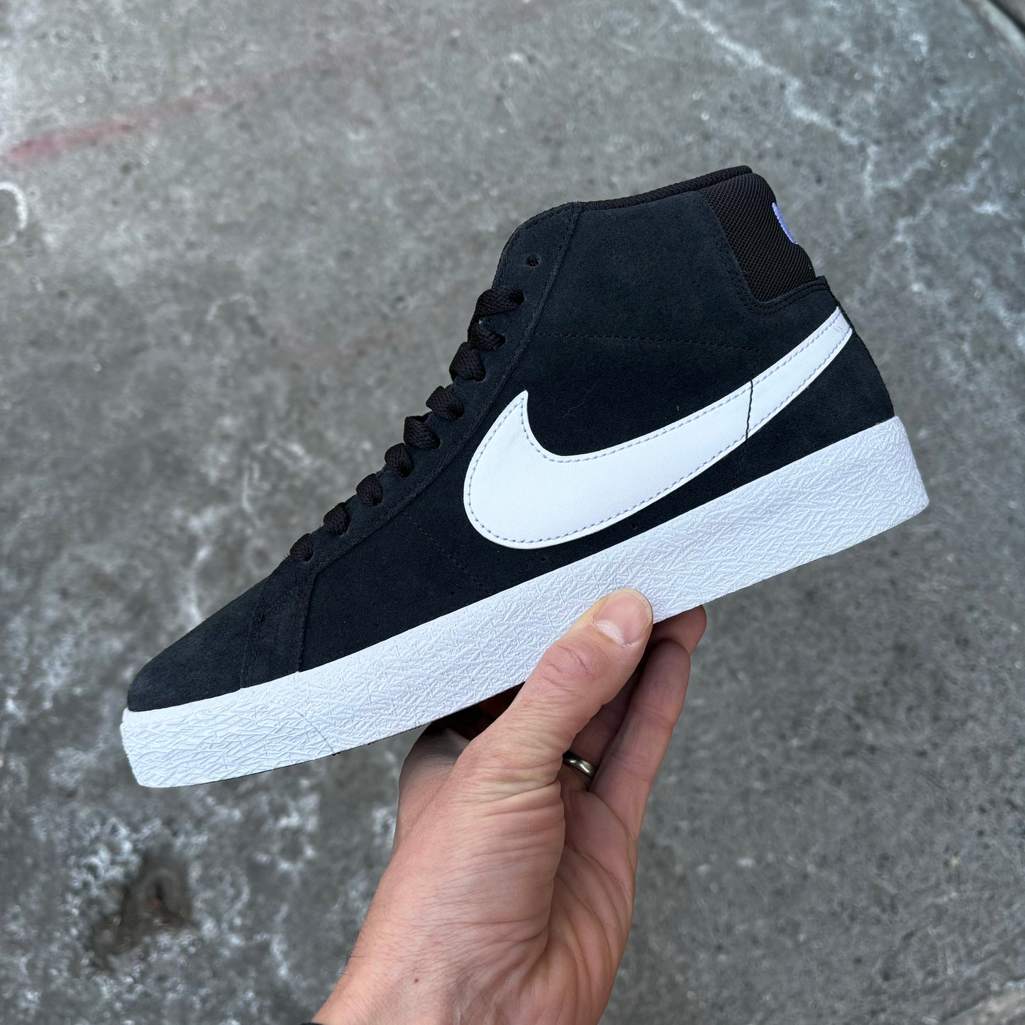 side view of black/white suede mid top skateboard sneaker