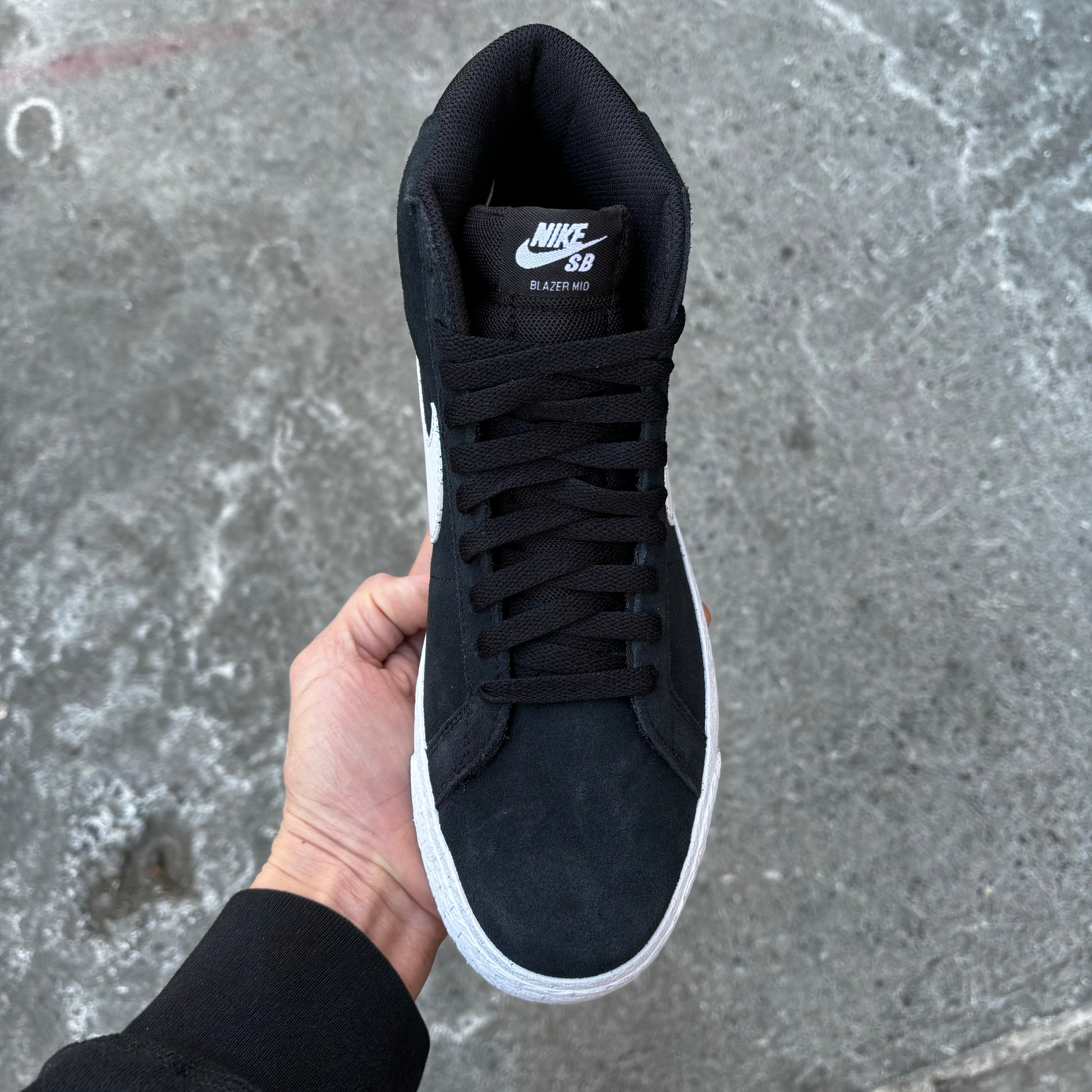 top down view of black/white suede mid top skateboard sneaker