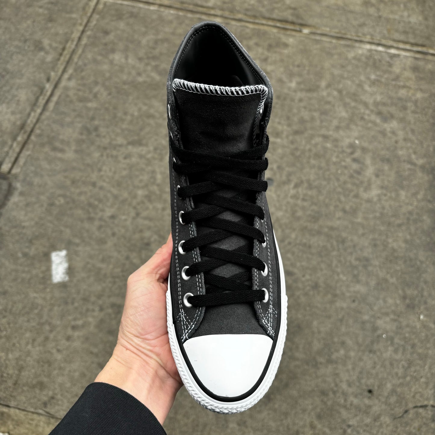 top down view of grey suede mid top sneaker with black laces