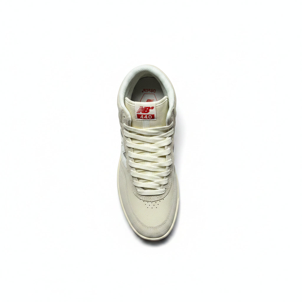 A single New Balance sneaker in off-white leather, shown from a top-down perspective on a white background