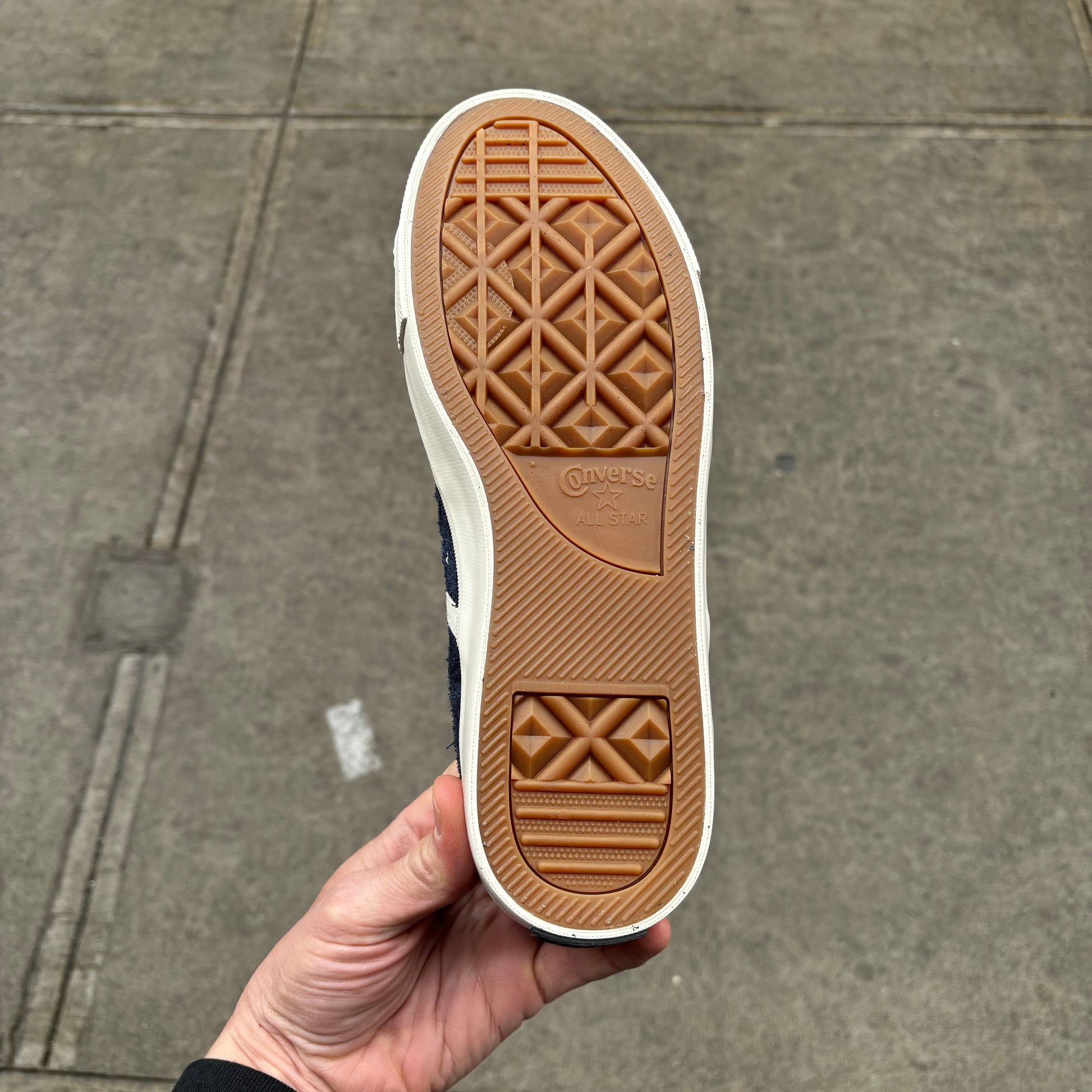 view of gum rubber outsole on low top suede skateboard sneaker