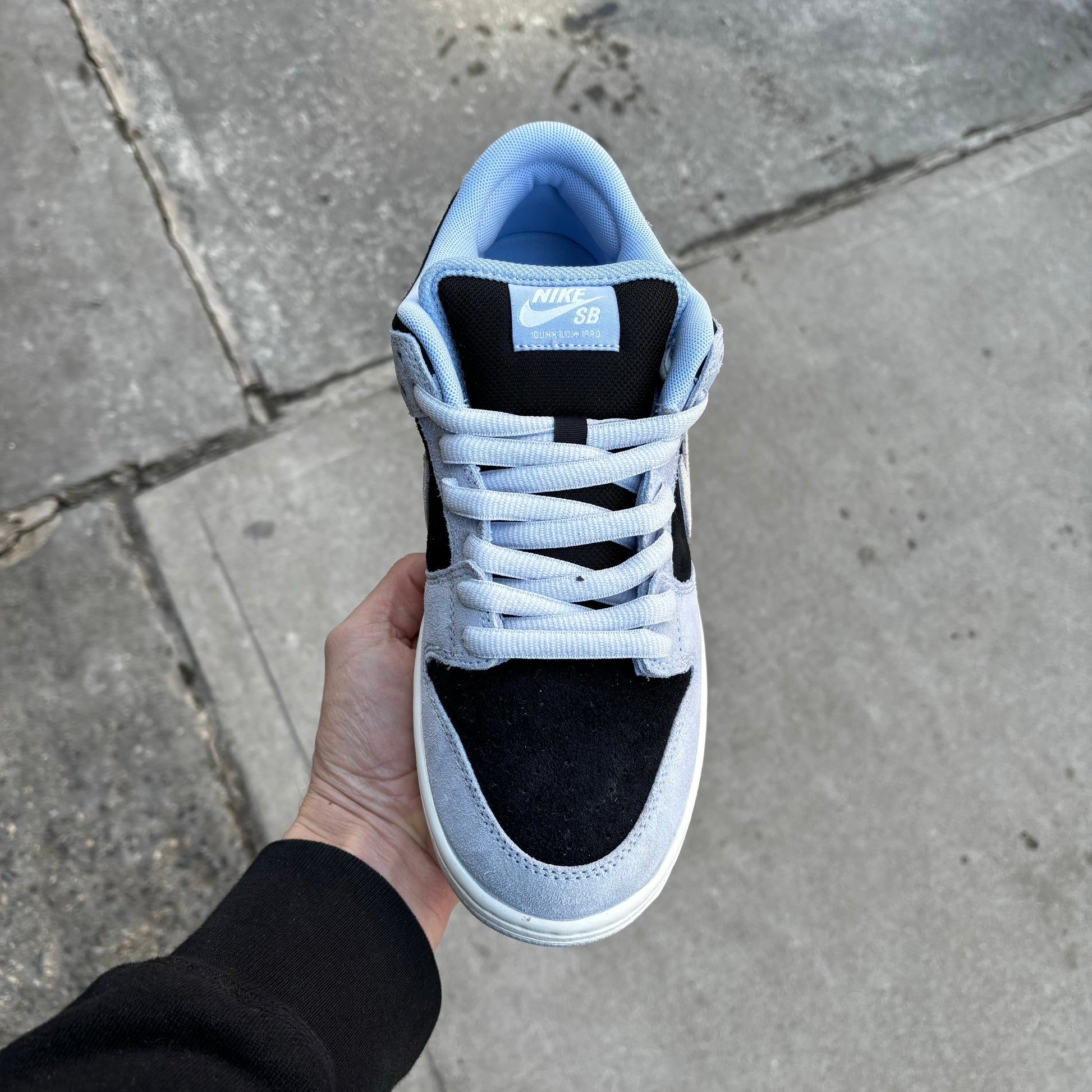 top down view of light blue, black and white suede sneaker