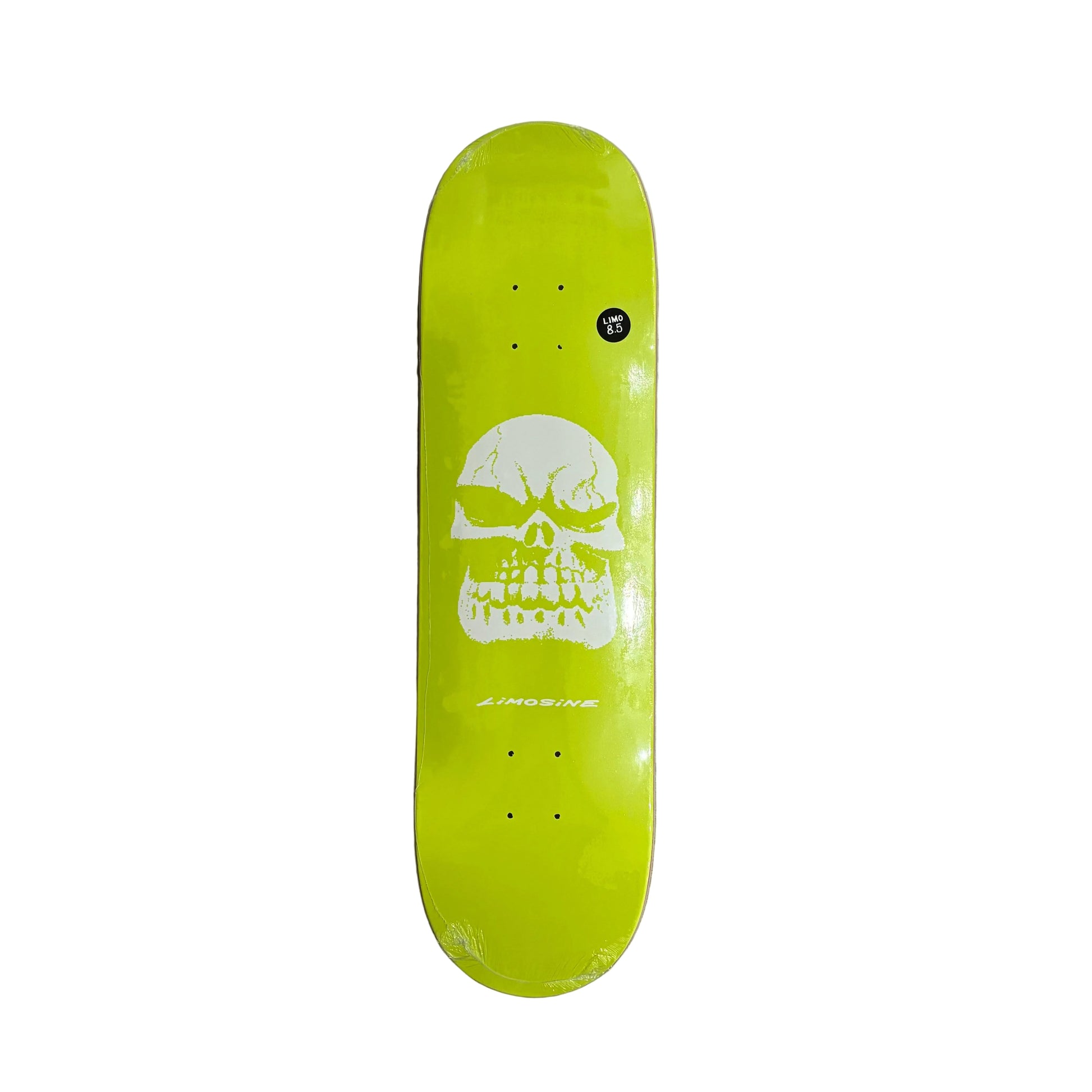 A skateboard deck with a bright lime green background and a large white skull graphic in the center, photographed from above on a white background
