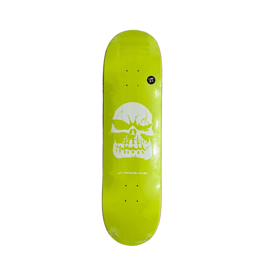 A skateboard deck with a bright lime green background and a large white skull graphic in the center, photographed from above on a white background