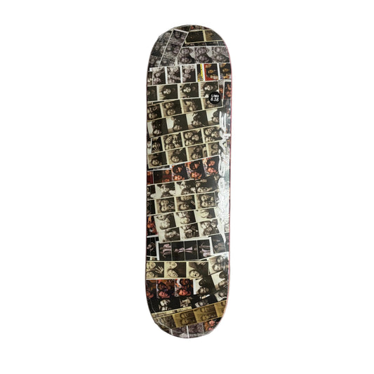 A skateboard deck featuring a collage print of numerous black and white portrait photographs, on a white surface