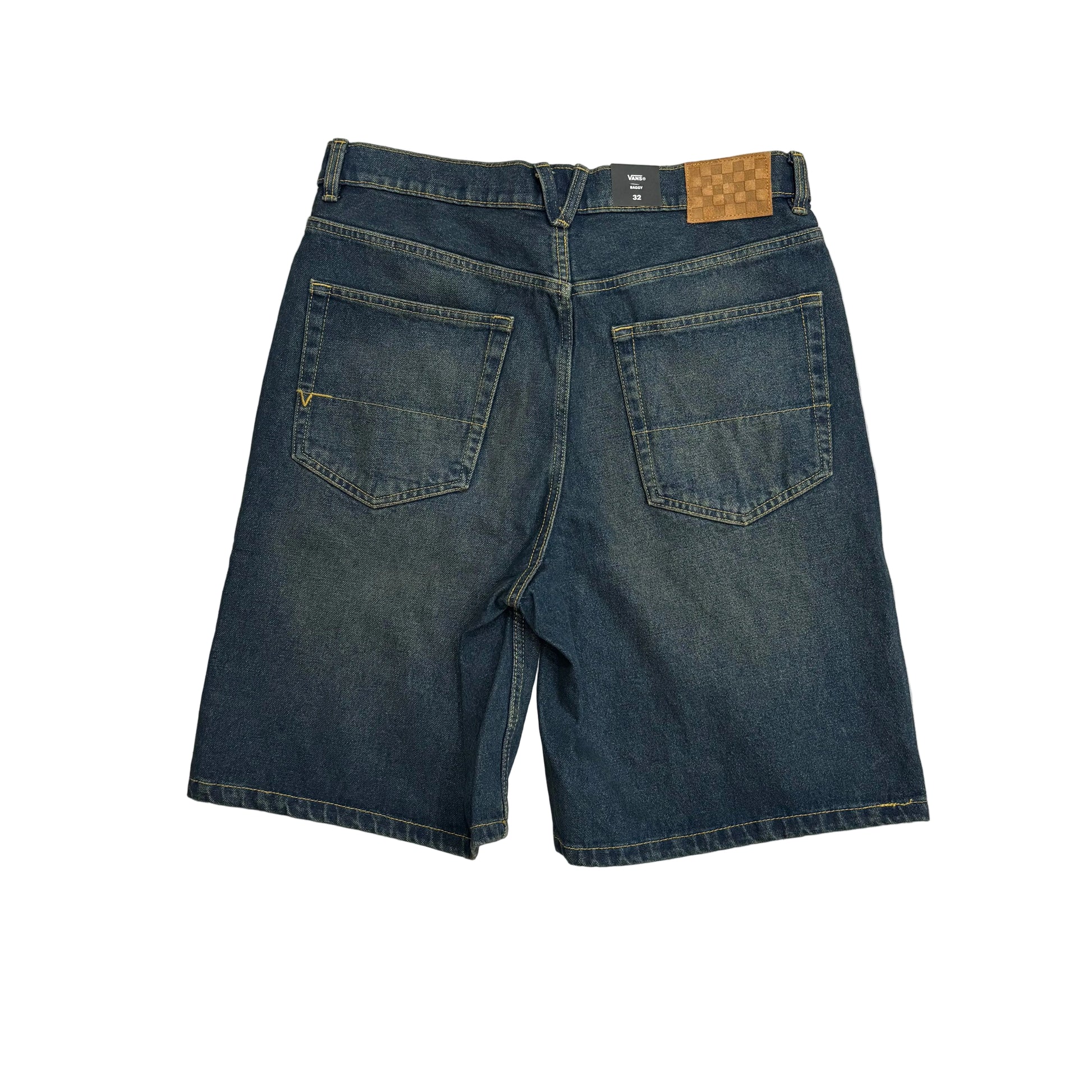 Back view of dark blue denim shorts with a brown patch on the waistband, laid flat on a white surface