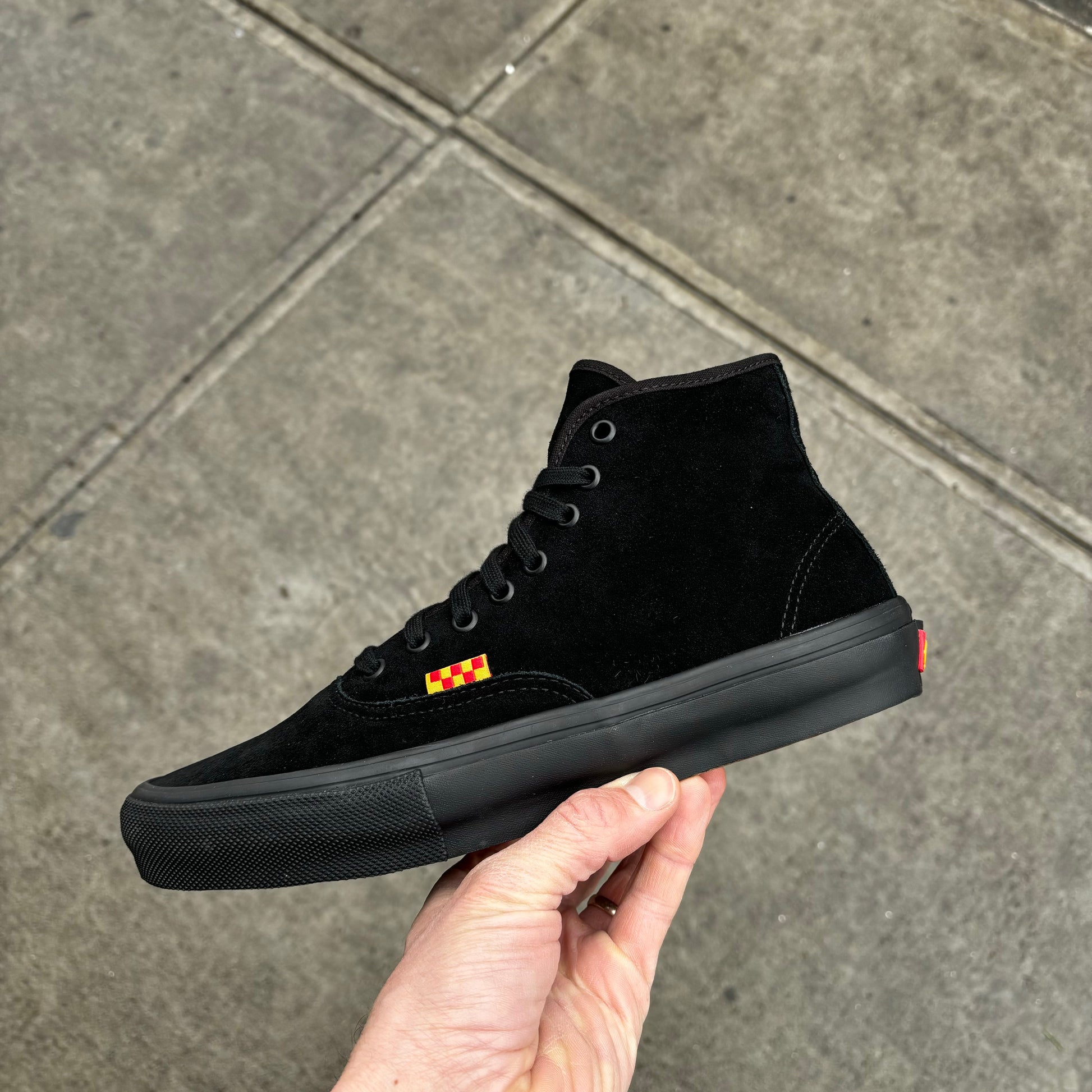 side view of black suede mid top skateboard sneaker