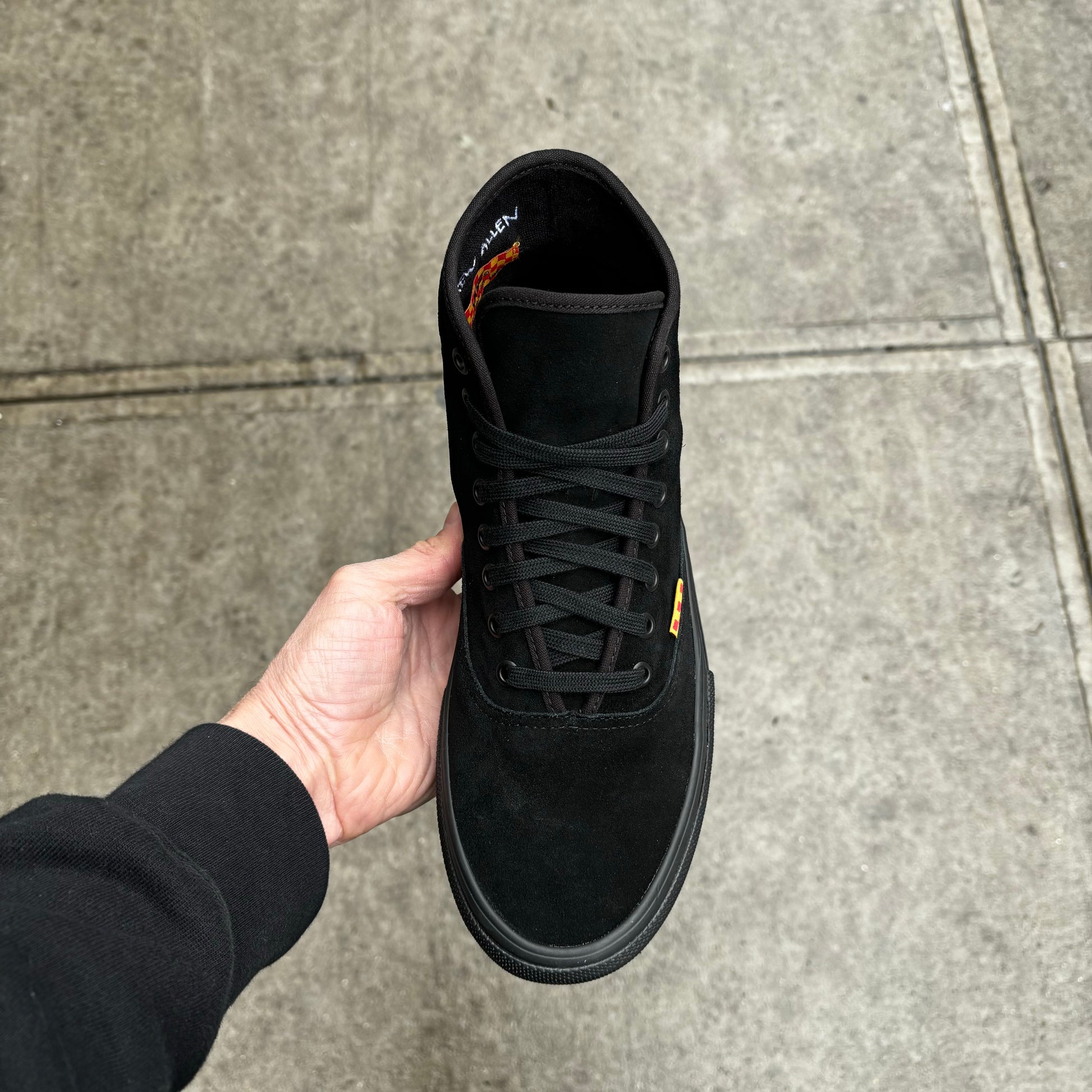 top down view of black suede mid top skateboard sneaker