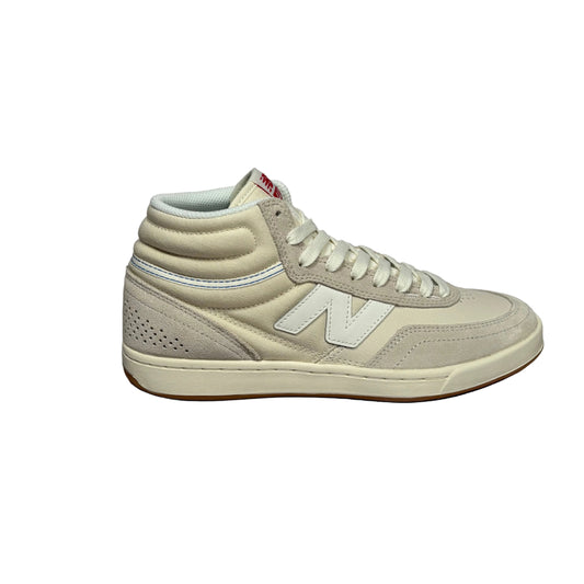 A single New Balance mid-top sneaker in light beige suede and mesh, shown from the side against a white background.