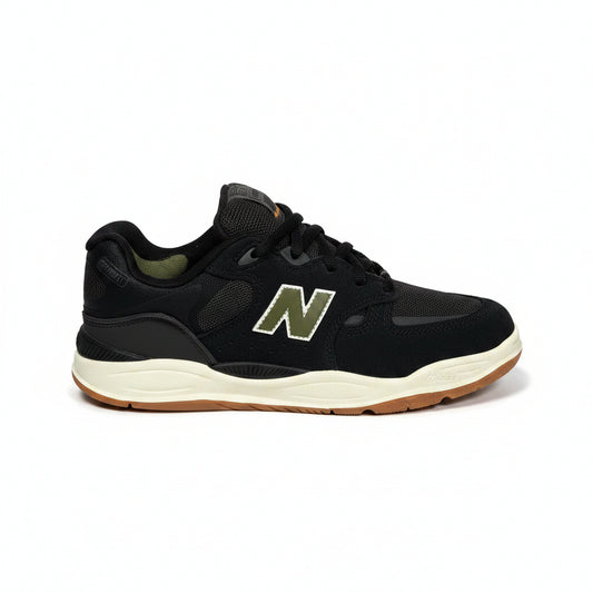A black New Balance sneaker with a green and white 'N' logo, black laces, and a cream midsole with a gum outsole, shown against a white background.