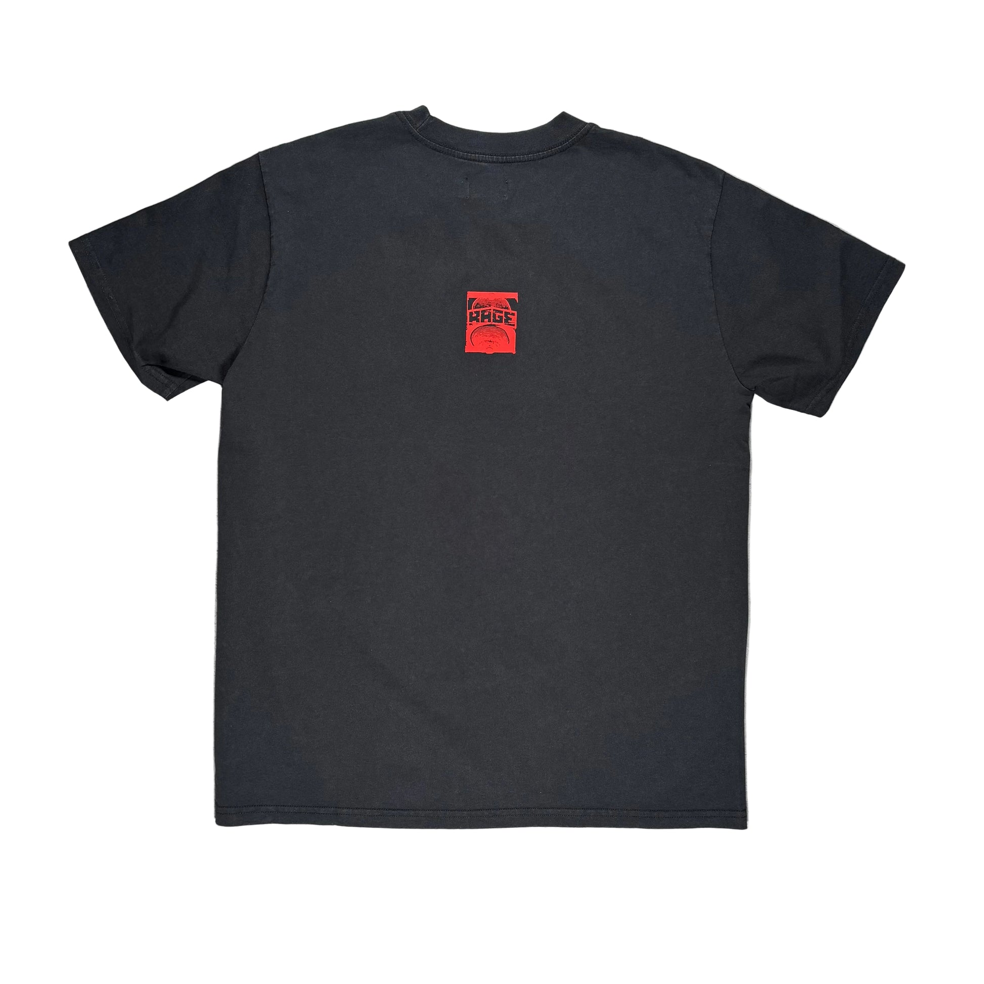 The back side of a black short-sleeve t-shirt laid flat on a white surface, featuring a small red square graphic on the upper left chest with the text 'RAGE'.