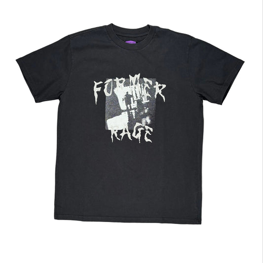 A black short-sleeve graphic t-shirt laid flat on a white surface, flanked by wooden boards on the sides. The shirt features a distressed white graphic print on the front reading 'FORMER RAGE' over a dark rectangular image.