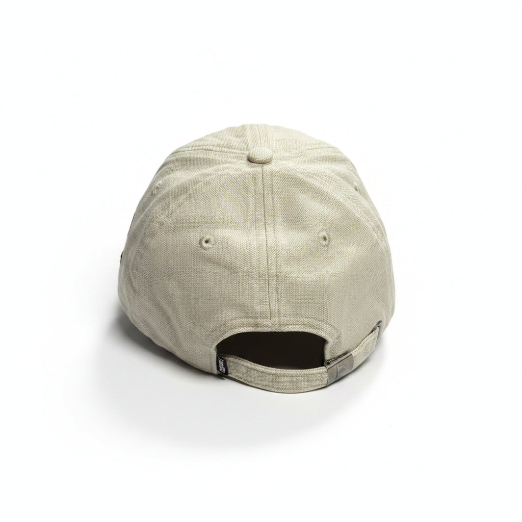 A light beige baseball cap viewed from the back, resting on a white surface.