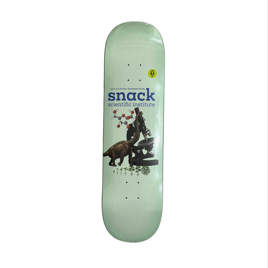 A mint green skateboard deck with a graphic of a scientist and a dog, featuring the 'snack scientific institute' logo, displayed on a white background.