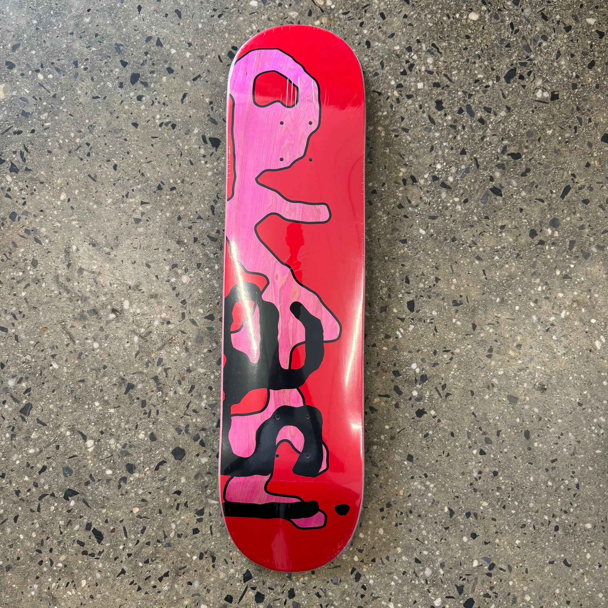 red skateboard deck with "quasi" on it in pink/black text