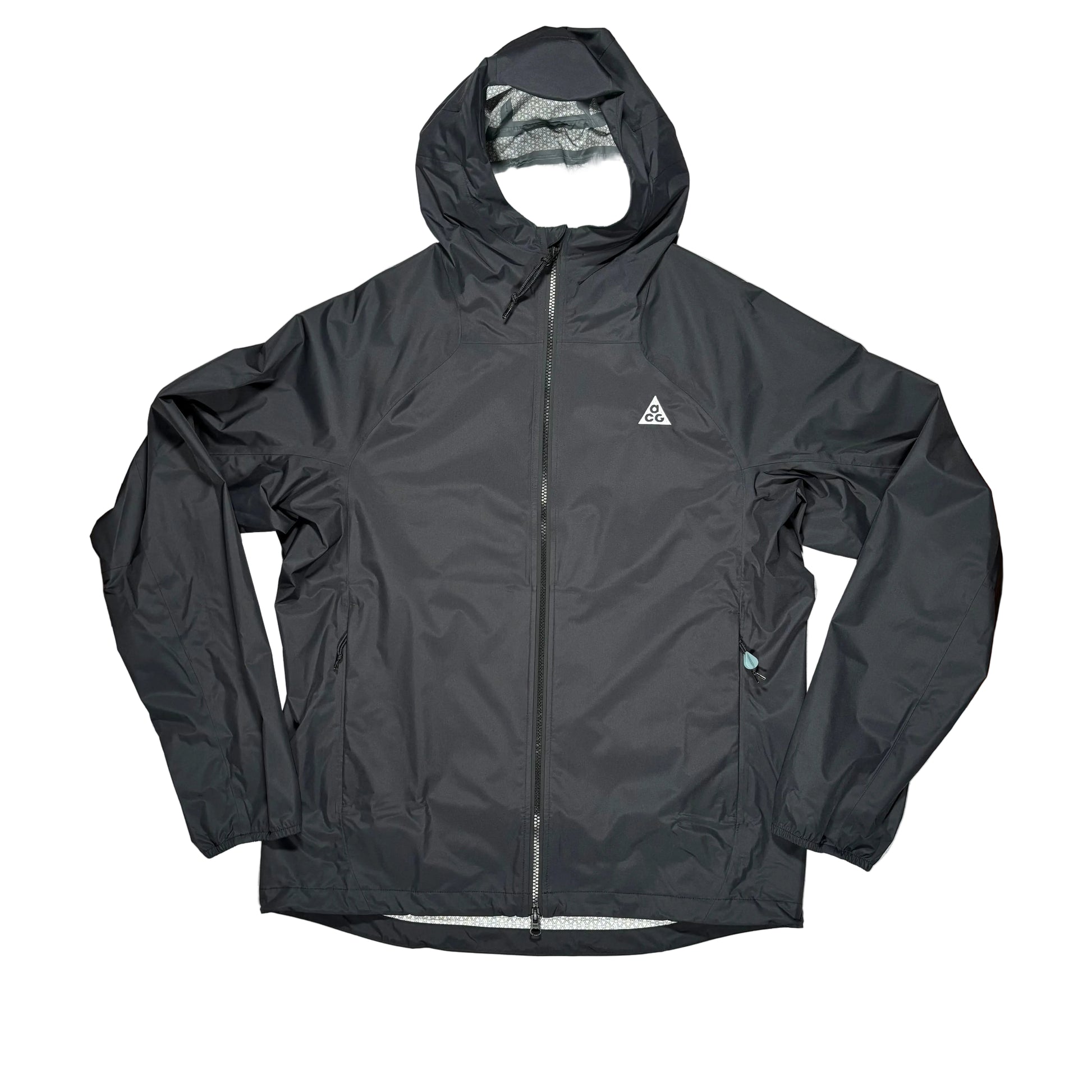 A black hooded zip-up jacket laid flat on a white surface with a small white triangular ACG logo on the left chest, photographed from above on a white surface.