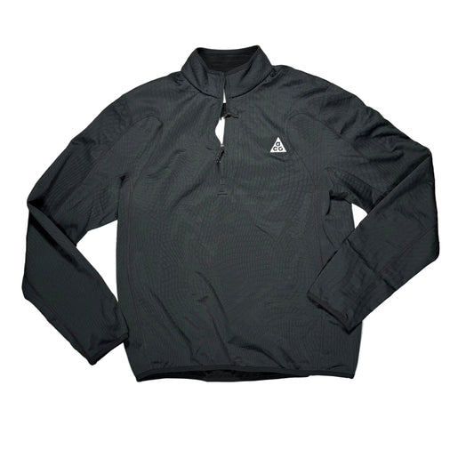A black long-sleeve quarter-zip pullover laid flat on a white surface, with a small white geometric triangle ACG logo on the left chest.