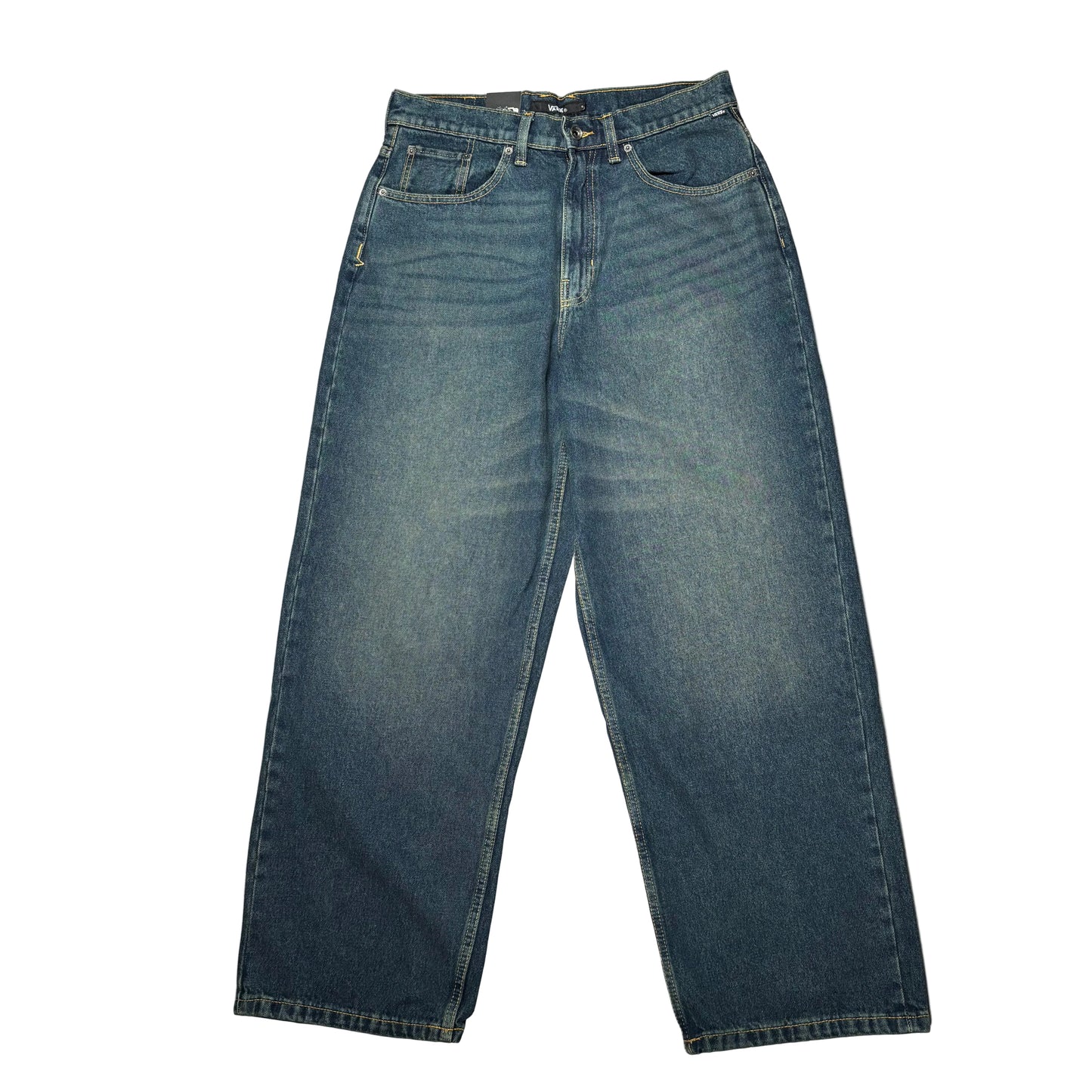 A pair of worn wash dark blue denim jeans laid flat on a white surface.