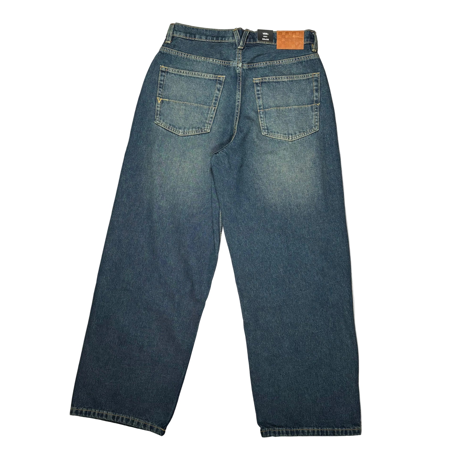 Back view of a pair of worn wash dark blue denim jeans laid flat on a white surface, photographed from above on a white surface.