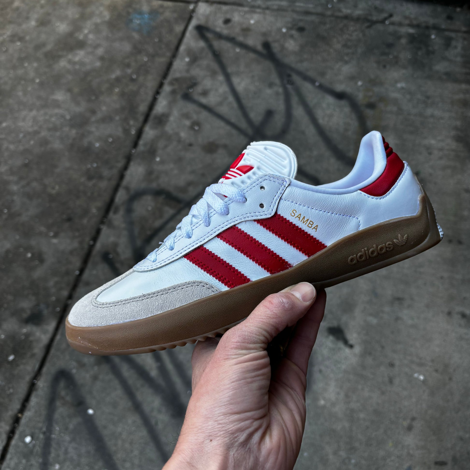 side view of white and red suede and leather lowtop sneaker with gum sole