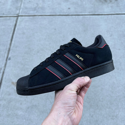 side view of black, red and gold suede lowtop skateboard sneaker