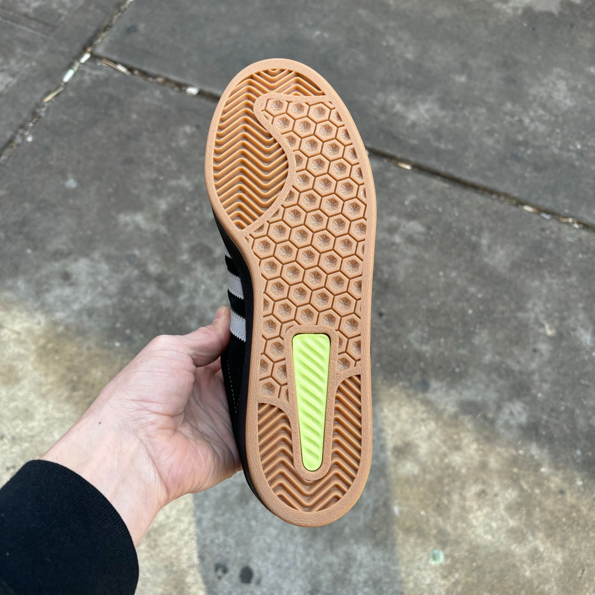 view of gum rubber outsole on lowtop black suede skateboard sneaker