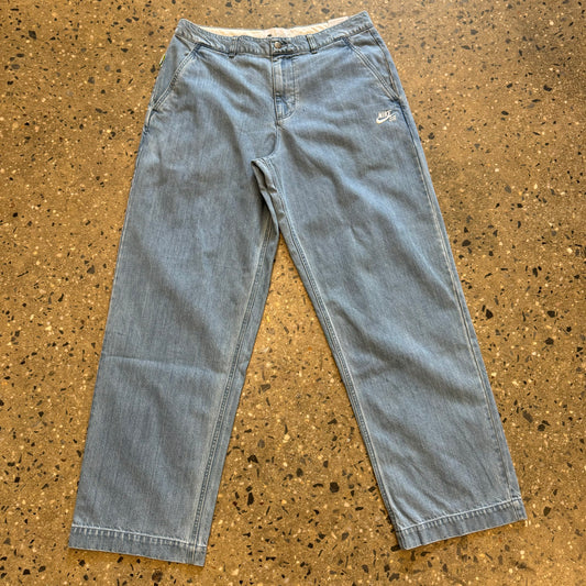 light blue washed denim chino pants with small nike embroidery near the pocket on the left