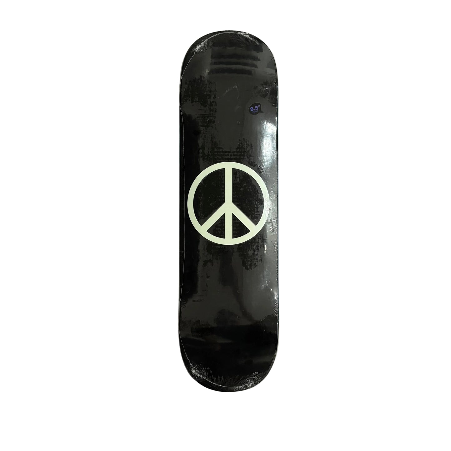 A black skateboard deck with a large white peace sign graphic in the center, photographed from above on a white surface.