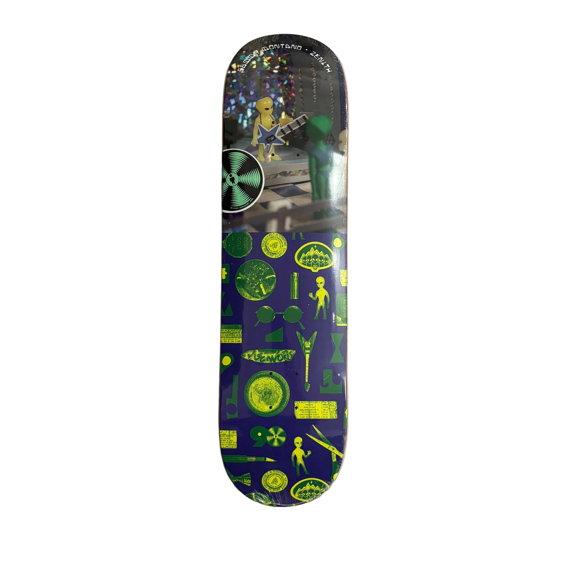 A skateboard deck with a dark blue and green alien-themed graphic design, photographed flat on a white surface.