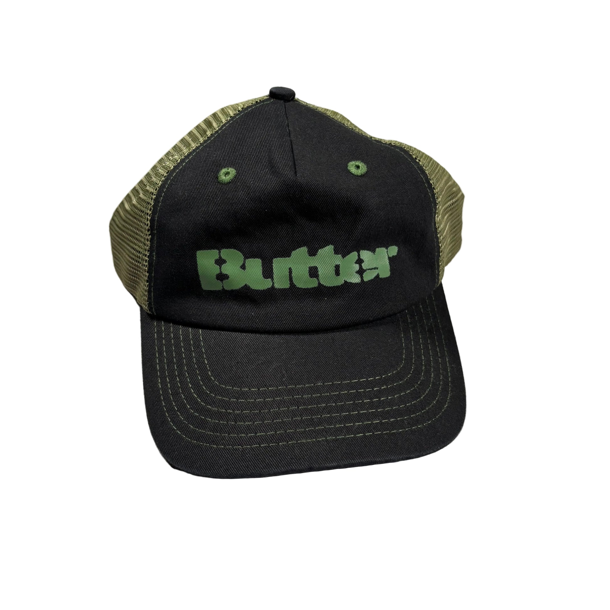 A black trucker hat with olive green mesh back panels and a green 'Butter' logo on the front, resting on a white surface.