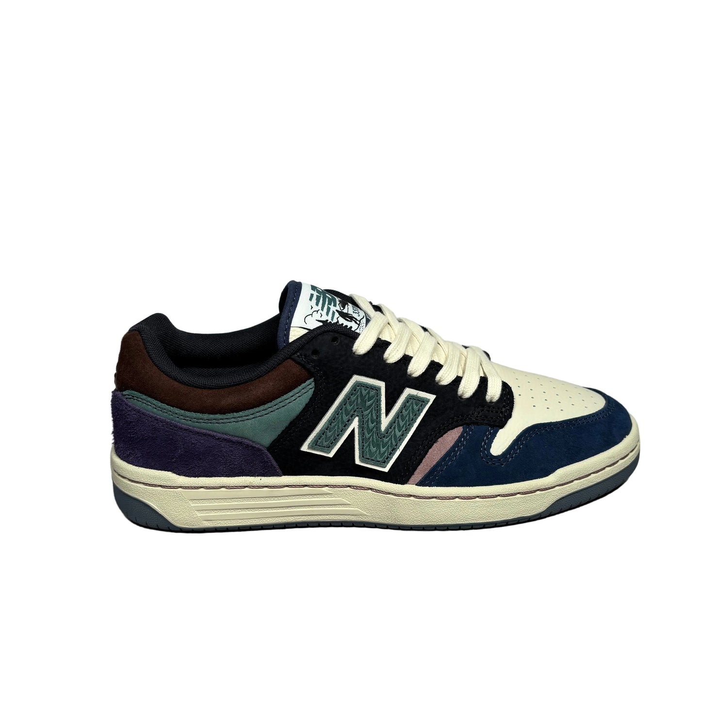 A New Balance sneaker in a multi-color colorway featuring navy suede, dark brown suede, purple suede, teal suede, off-white leather, and a cream midsole, shown from the side against a white background.