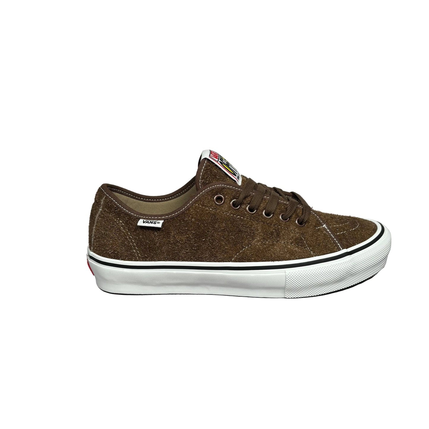 A brown suede low-top sneaker with a white rubber sole with black stripe, shown from the side against a white background.