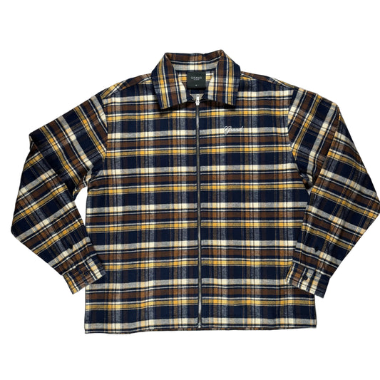 A zip-up plaid flannel shirt jacket in navy, mustard yellow, brown, and cream, laid flat on a white background.