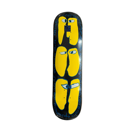 A skateboard deck featuring a black background with three large yellow abstract shapes, each with small blue and white eyes, bordered by blue squiggly lines and the word 'wknd' in white near the bottom. Displayed on a white surface.