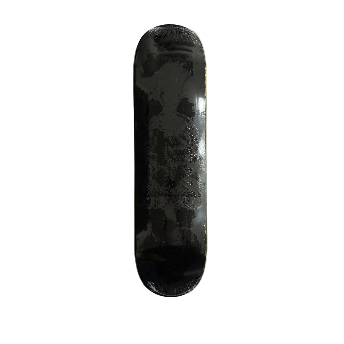 A black skateboard deck, showing a faint graphic design, photographed from directly above on a white surface.